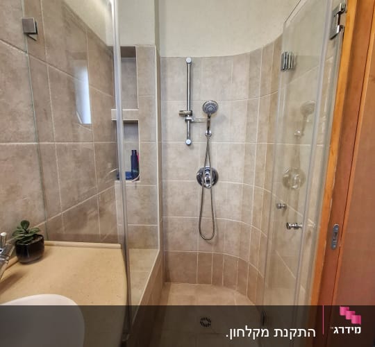 מקלחת עם דלת זכוכית וראש מקלחת